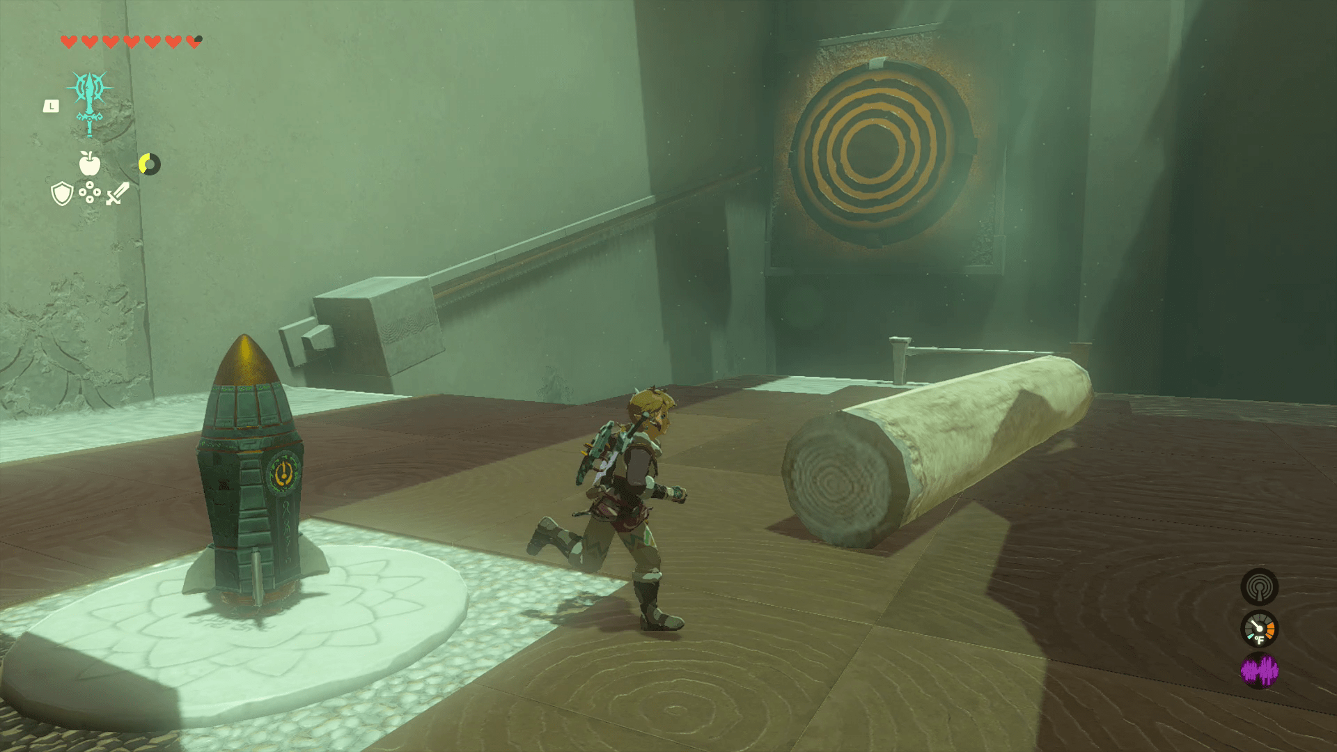 Link jogs around the first room in Oshozan-u Shrine, which contains a log, a rocket, a stone affixed to a slider on the wall, and a big yellow target on an adjacent wall