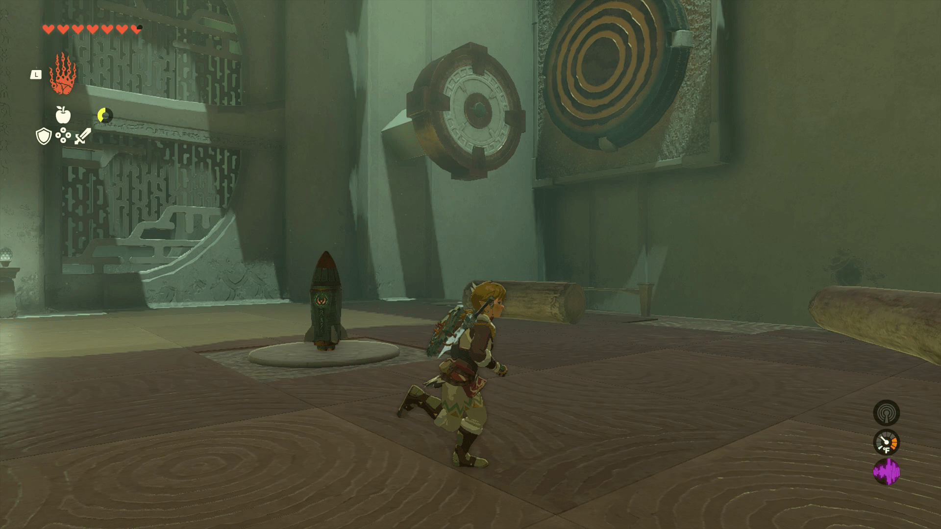 Link jogs around the second cavern in Oshozan-u Shrine, which contains two logs, a rocket, a gear on the wall, and a yellow target on an adjacent wall