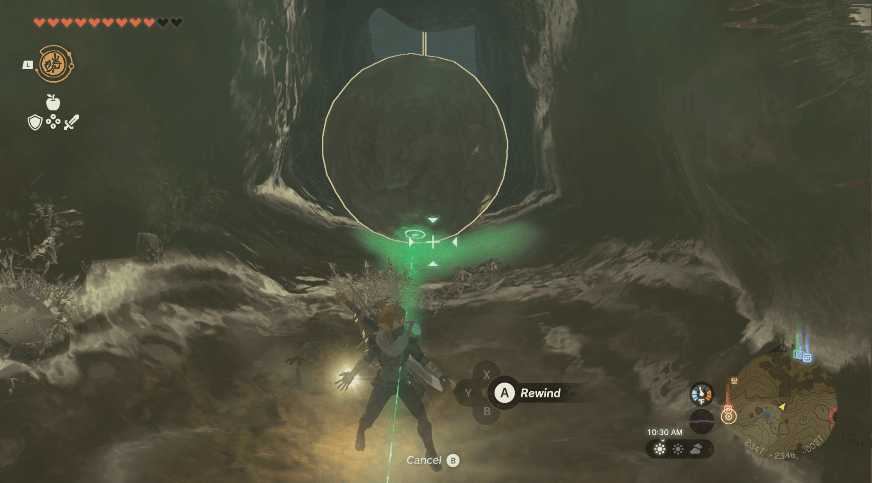 Link using Recall on a falling boulder in The Legend of Zelda: Tears of the Kingdom. It’s in a dark narrow cave and the power makes the surroundings glow yellow.