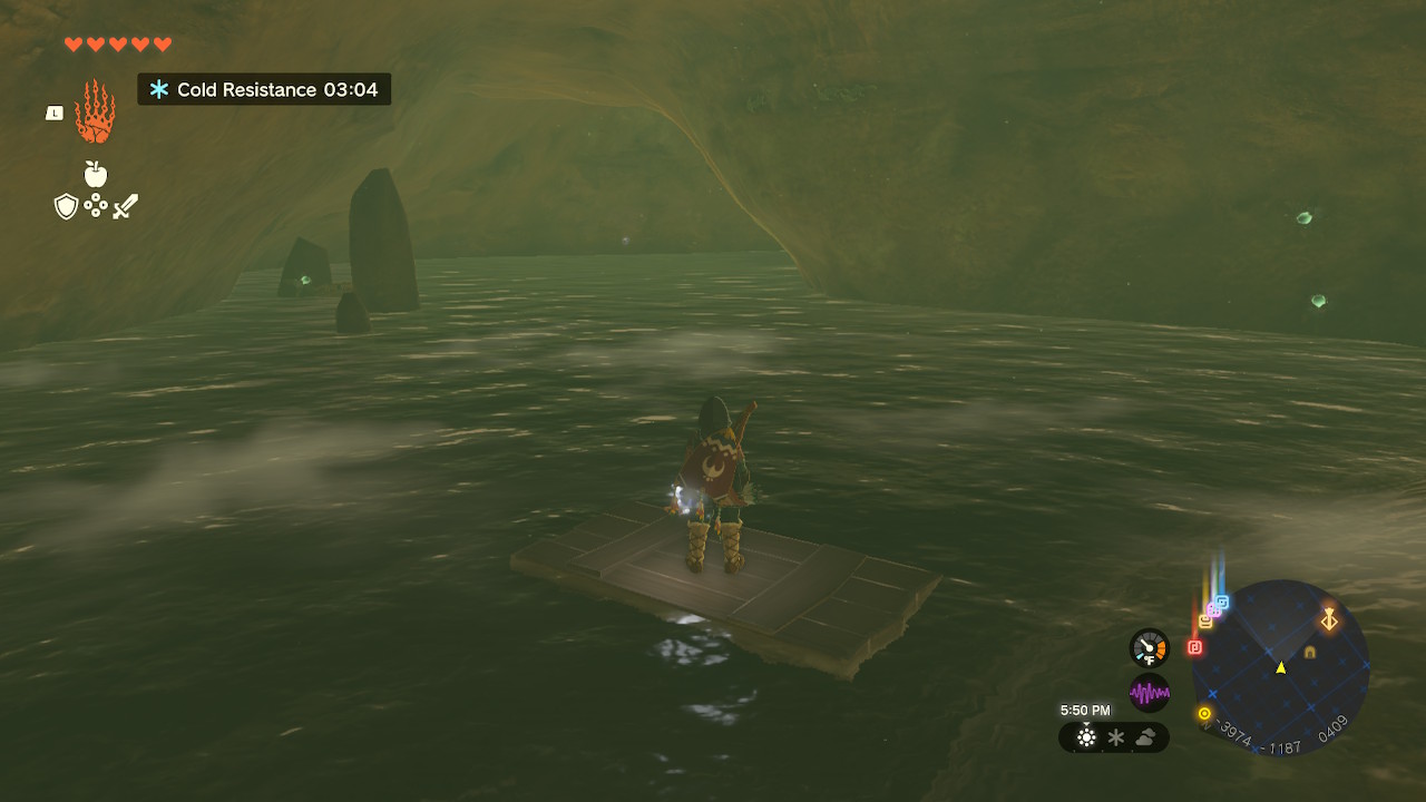 Link surfs downstream on a piece of wood inside a dimly lit cave in Zelda: Tears of the Kingdom