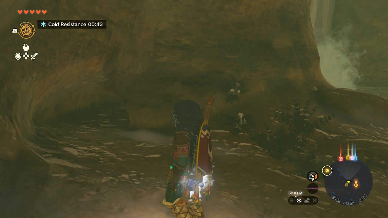 Link looks at a small passage that leads to a chest in a dimly lit cave in Zelda: Tears of the Kingdom
