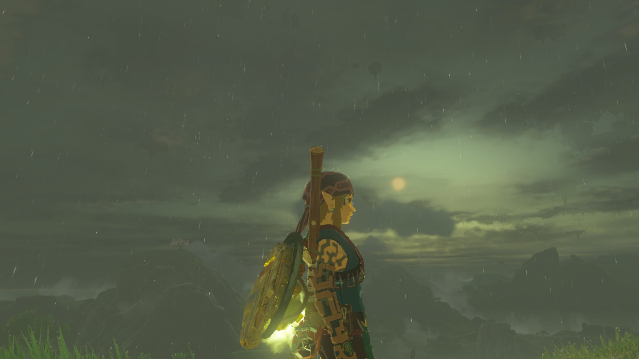 Link stands on the side during a rainy evening with the sun in the distance wearing the Climbing Armor in Zelda: Tears of the Kingdom