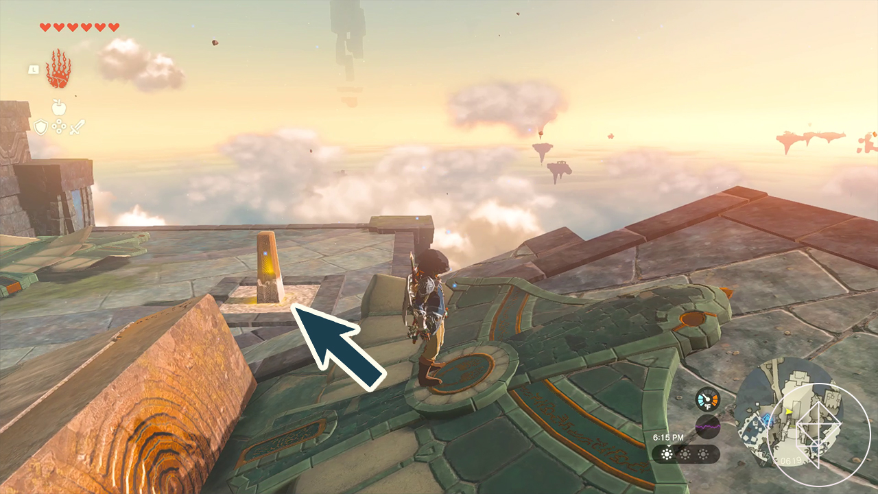 Link stands facing right over a jutting decorated stone outcropping that’s shaped like a large bird. A superimposed arrow pointing to 11 o’clock indicates a yellow switch the player needs to attack to activate the bird and launch it.