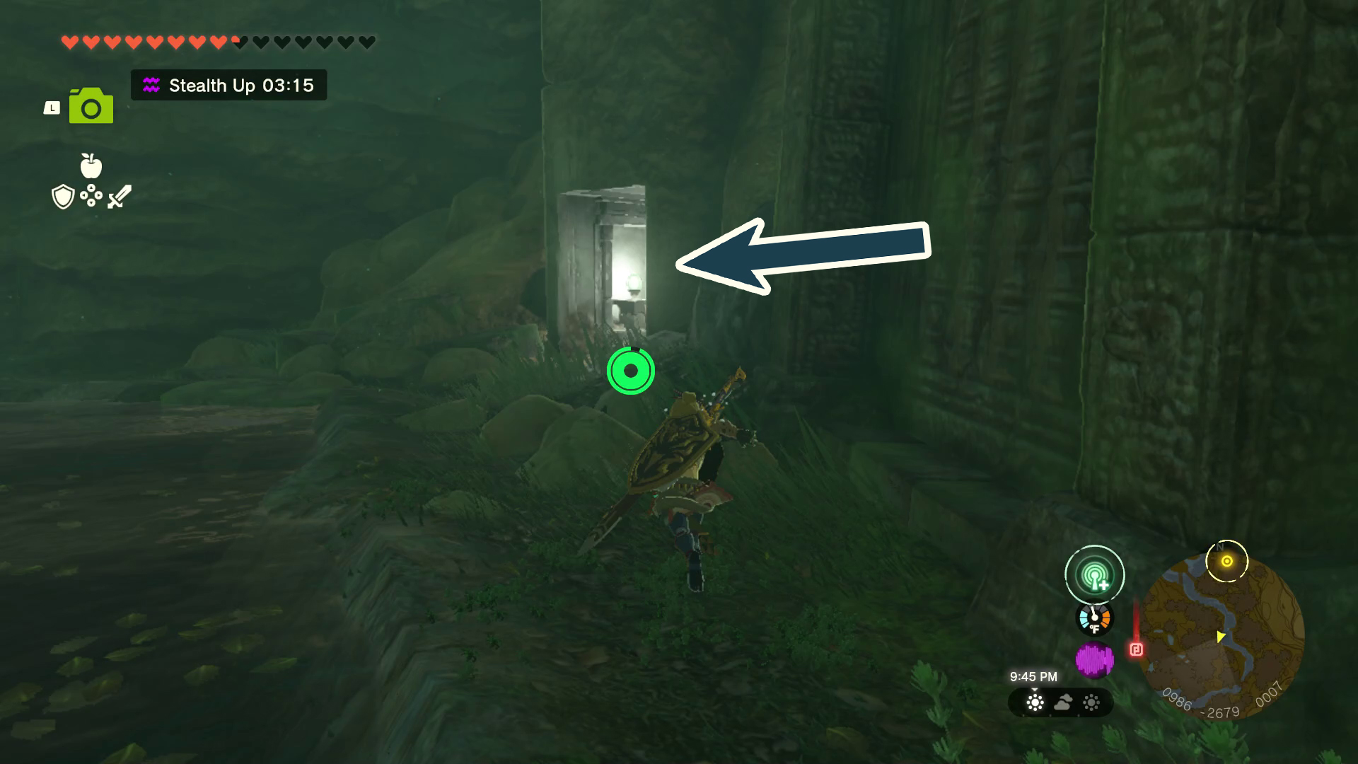 An arrow points to a lit up doorway in the night baked into some ruins in Tears of the Kingdom. Link hurdles over rocks to head over to the entrance.