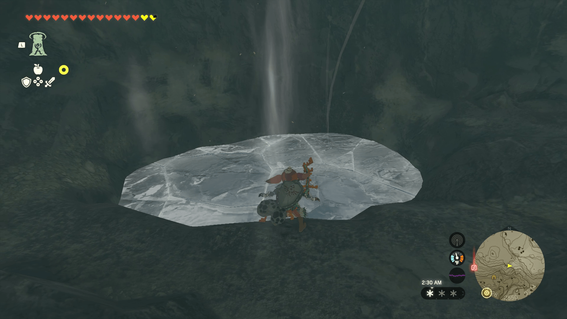 Link crouches before a flat circle of ice on a cave floor. Wind is coming up from the ice in large gusts.