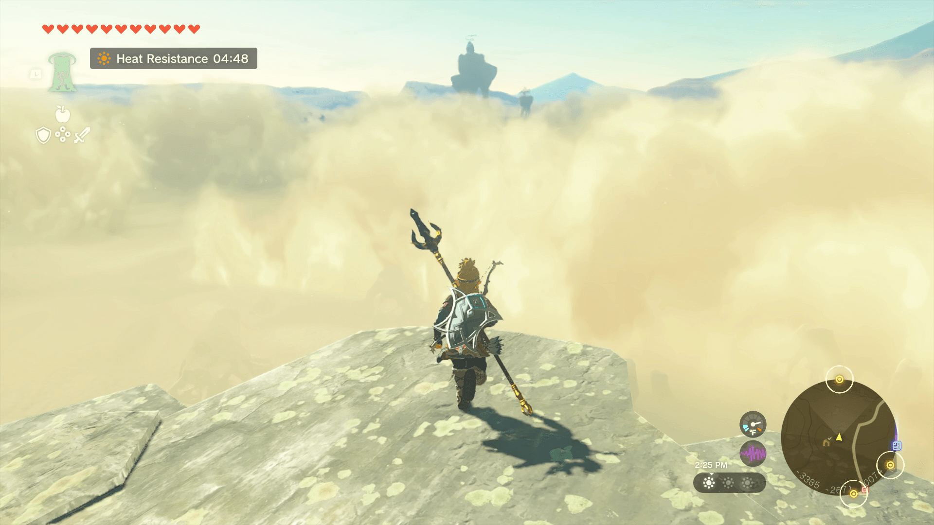 Link stands on a tall rock that oversees the sandstorm in Gerudo Desert in Tears of the Kingdom