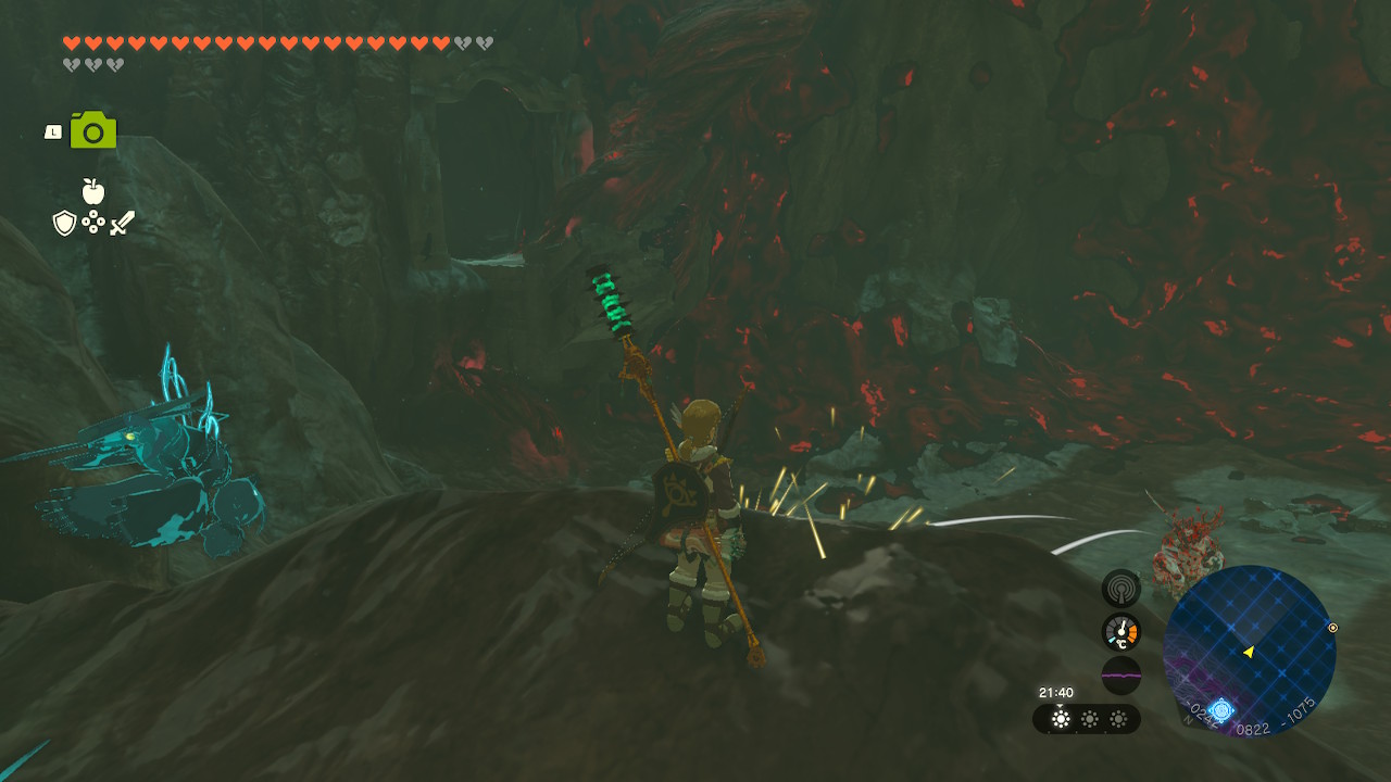 Link stands on a rocky outcropping a short glide from a hole in the wall while in a chasm under Hyrule Castle in Zelda Tears of the Kingdom.